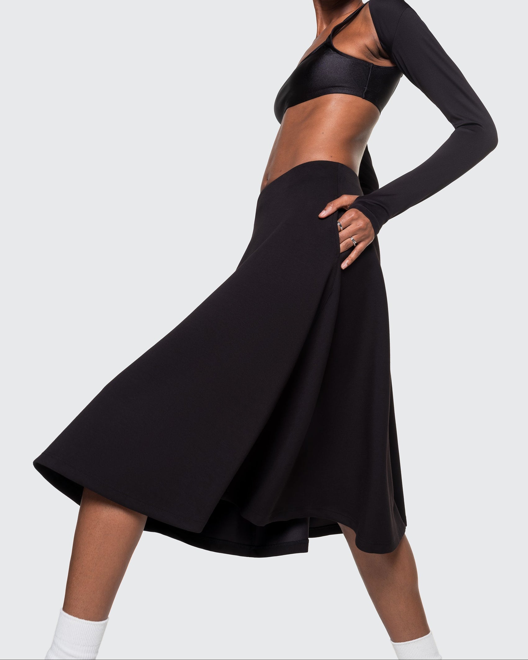 Model wearing 12Twelve Heavenly Skirt in black with asymmetric long sleeve top