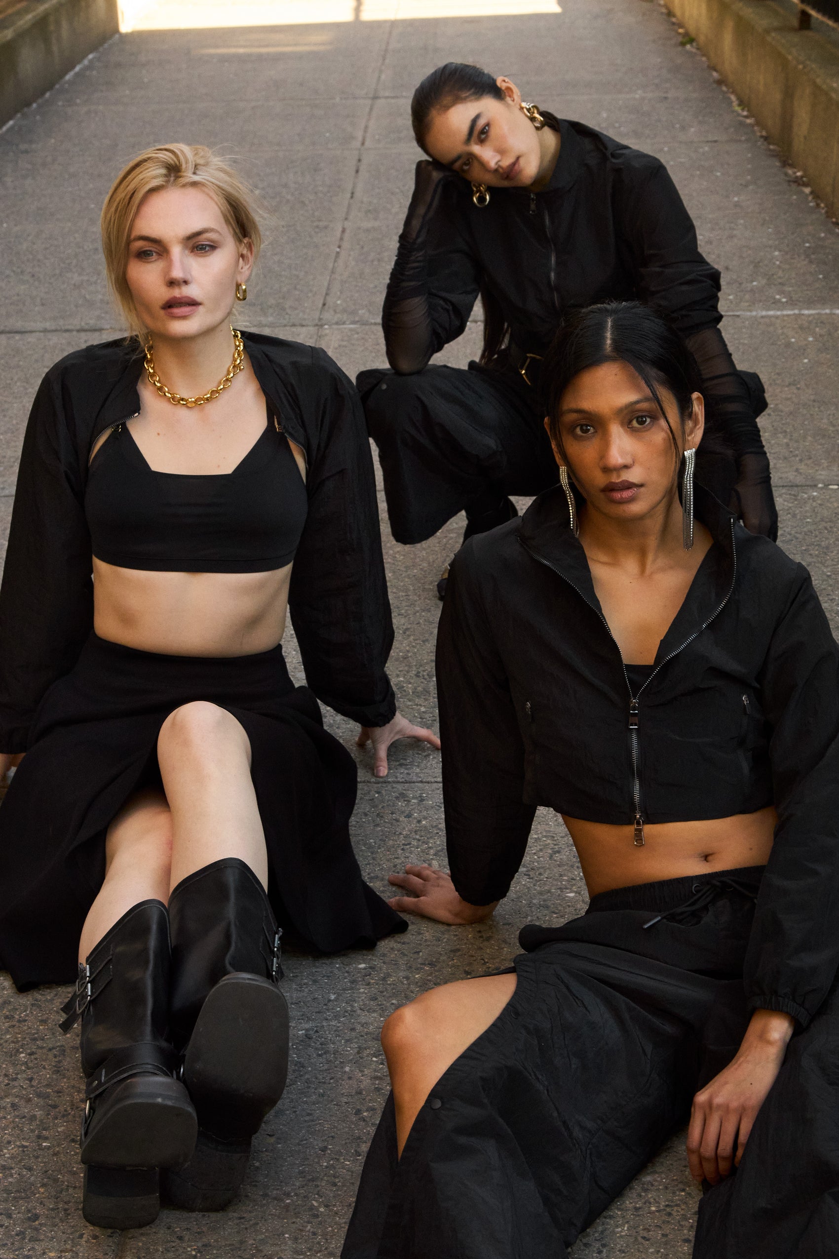 Models wearing 12Twelve’s Off-Duty Set featuring the Track Pants and Crop Jacket in black, styled with the Heavenly Skirt and Sienna Clay Frame Knit.