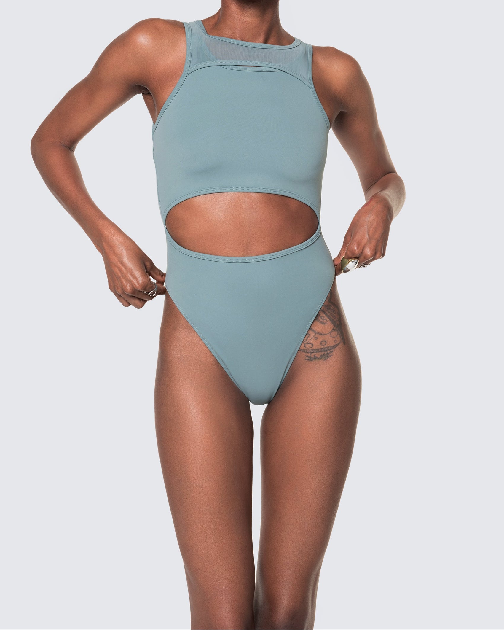 Model wearing 12Twelve tide blue bodysuit with scoop neckline and waist cut-out