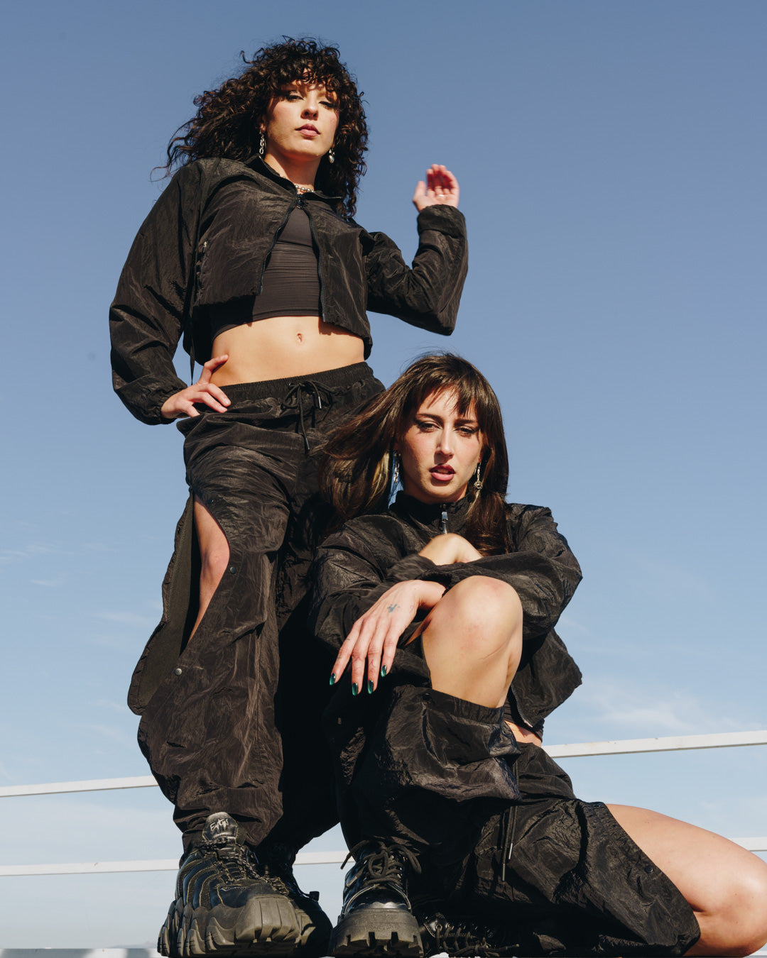 Two models in the 12Twelve Off-Duty Set, highlighting the cropped black jacket styled with matching Track Pants.