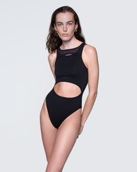 Model wearing 12Twelve black cut-out bodysuit with high-leg and scoop neckline