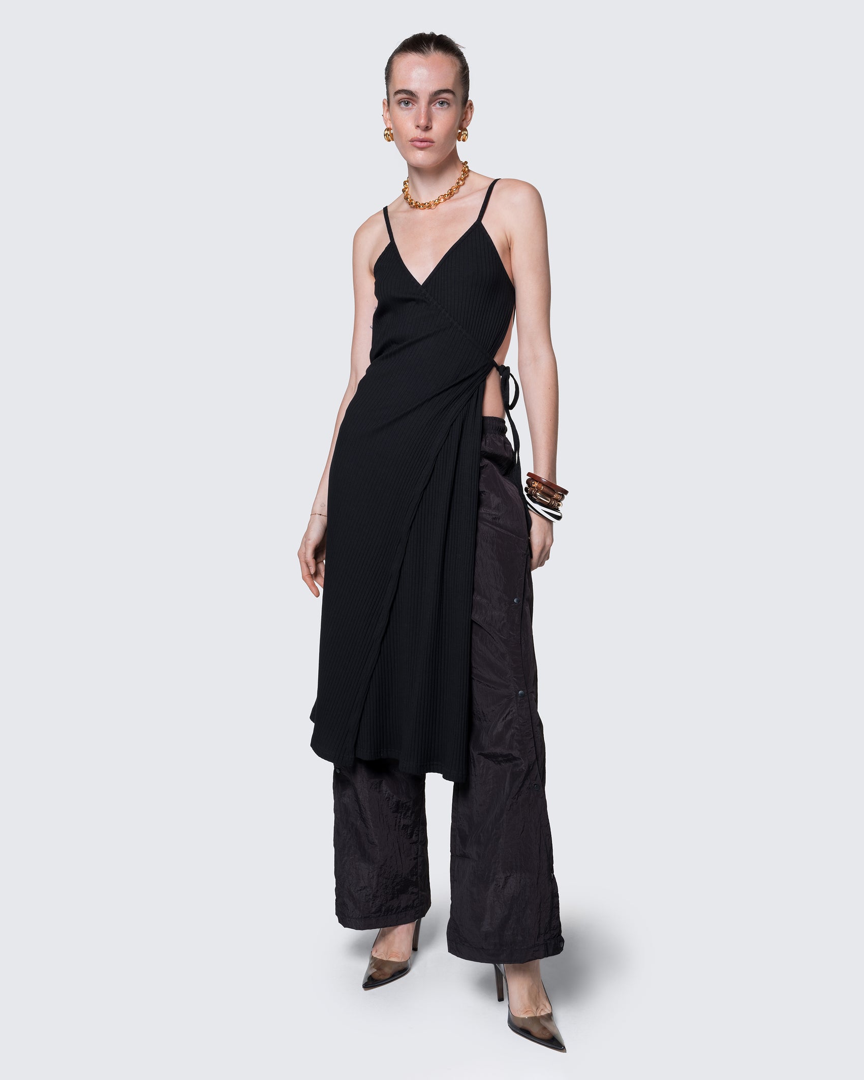 Model wearing 12Twelve Reversible Wrap Dress in black layered over track pants