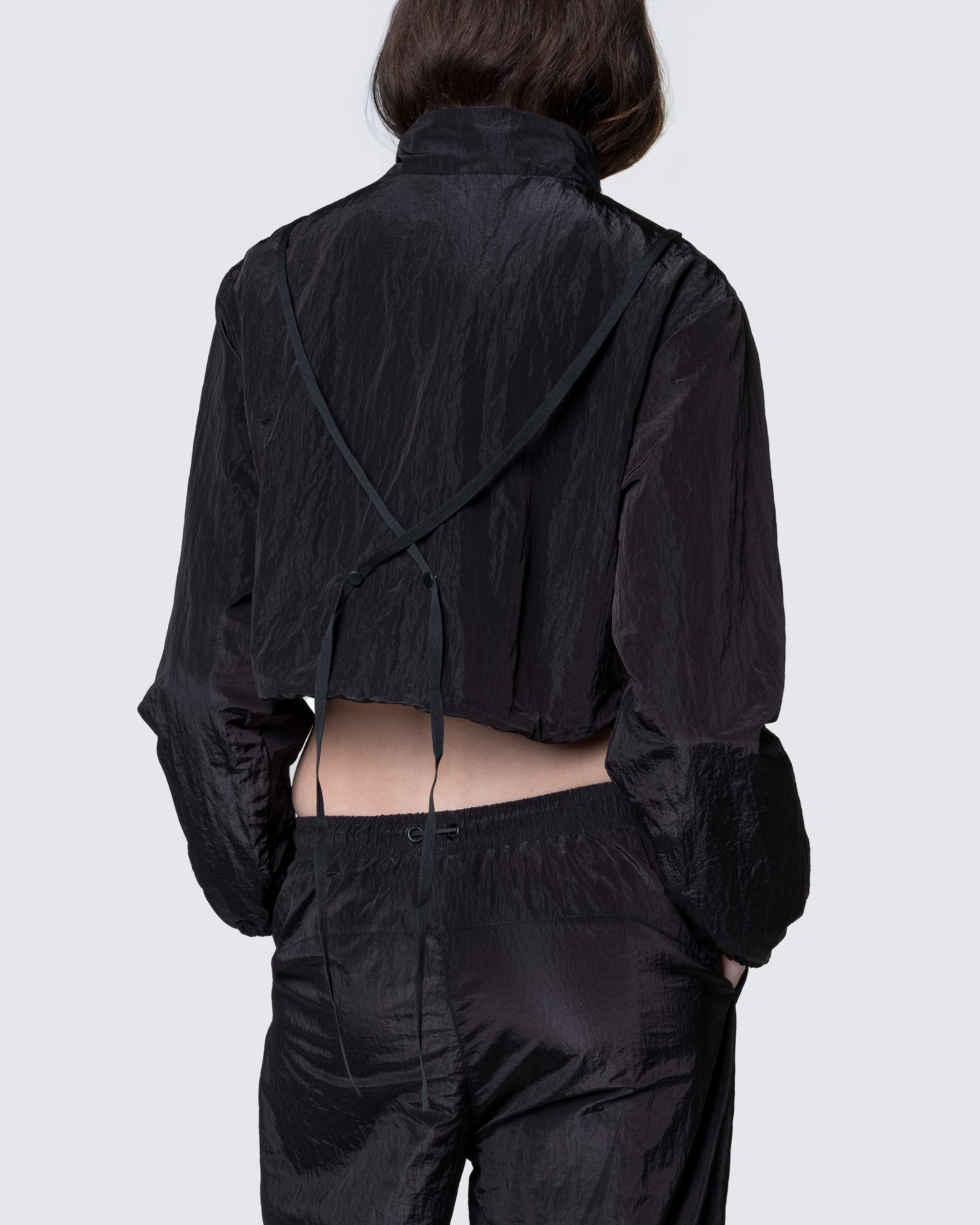 Back view of 12Twelve black crop jacket highlighting cropped cut and gathered waistband