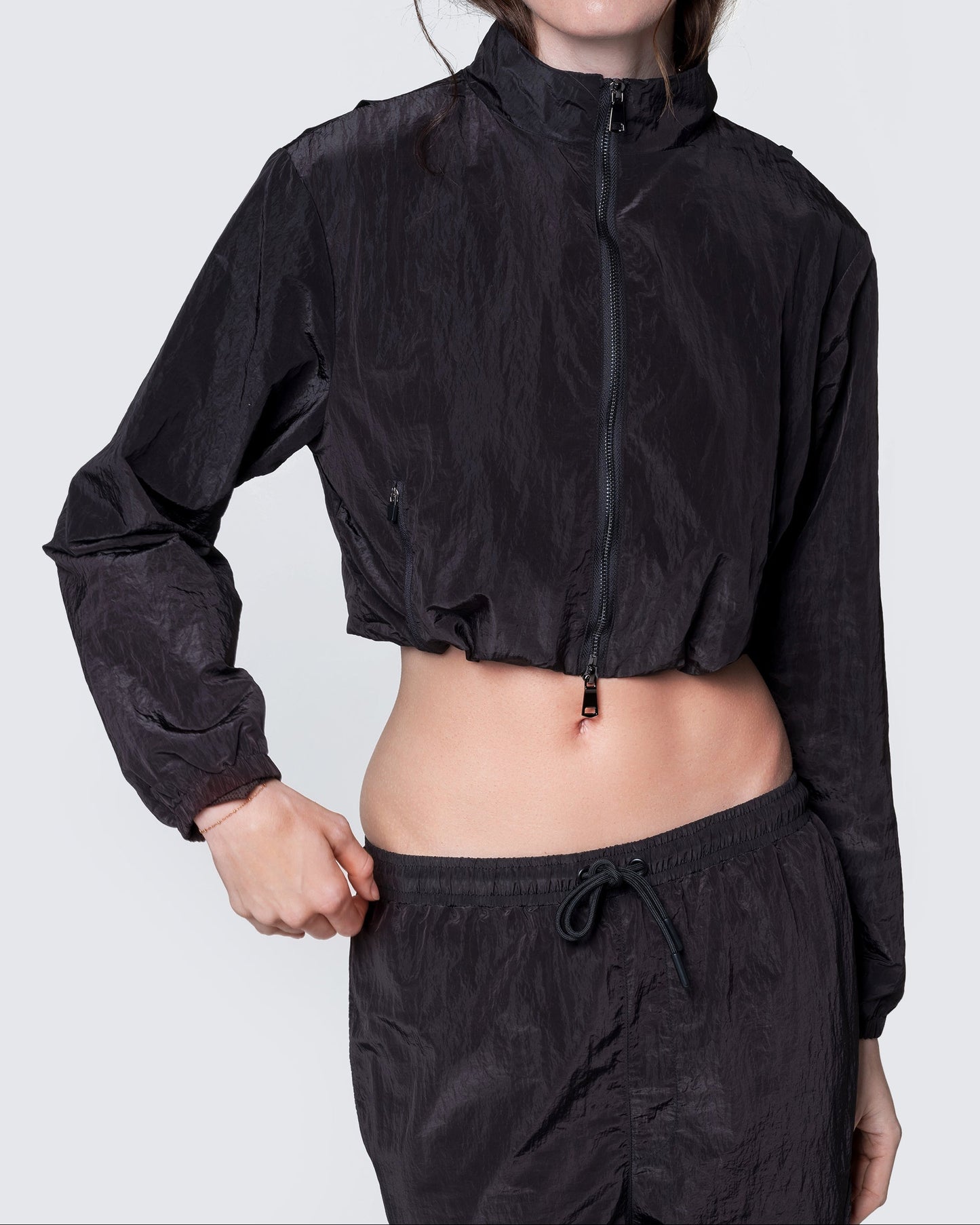 Model wearing 12Twelve black crop jacket zipped up, showing relaxed fit and high collar