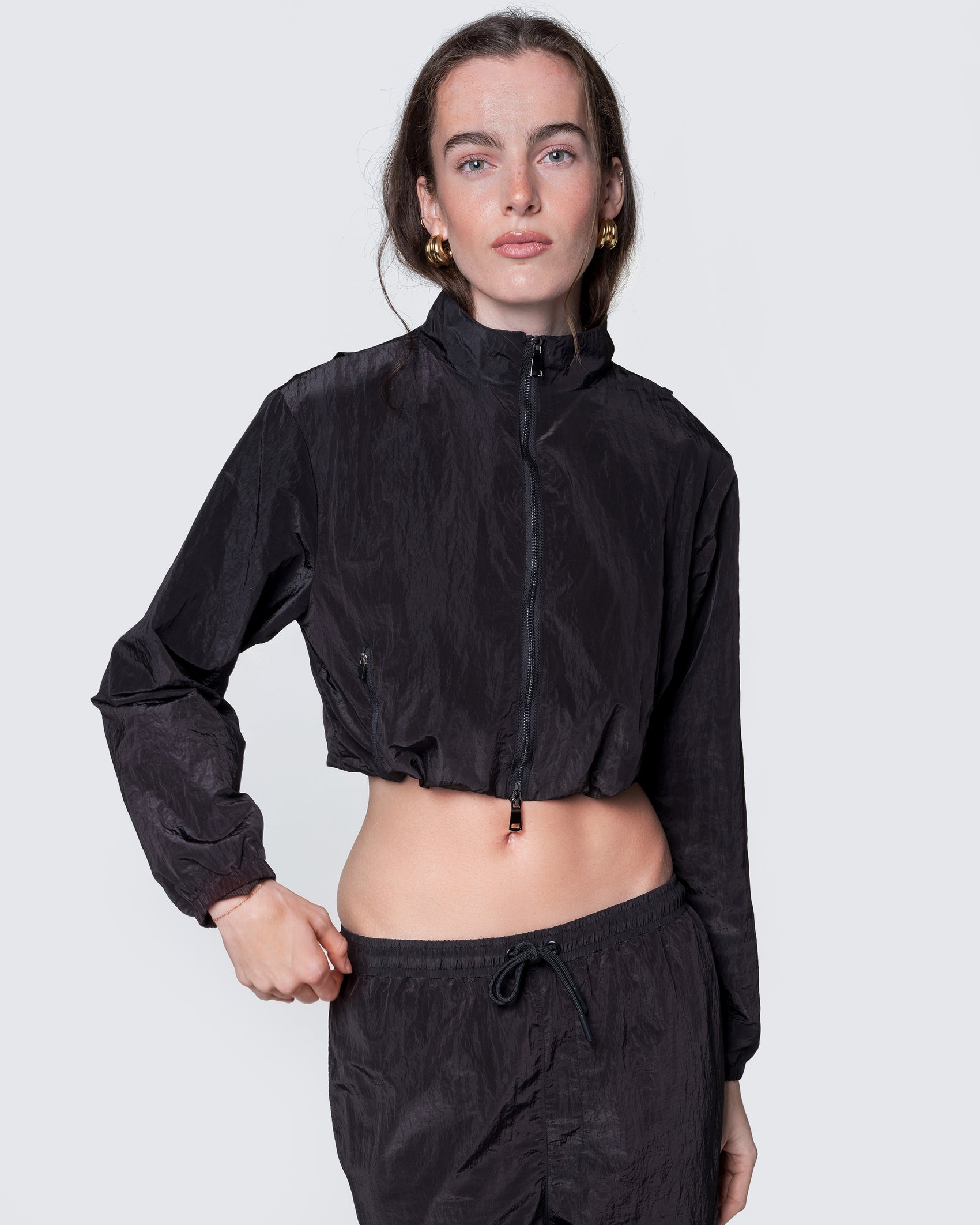 Model wearing 12Twelve black crop jacket zipped up, showing relaxed fit and high collar