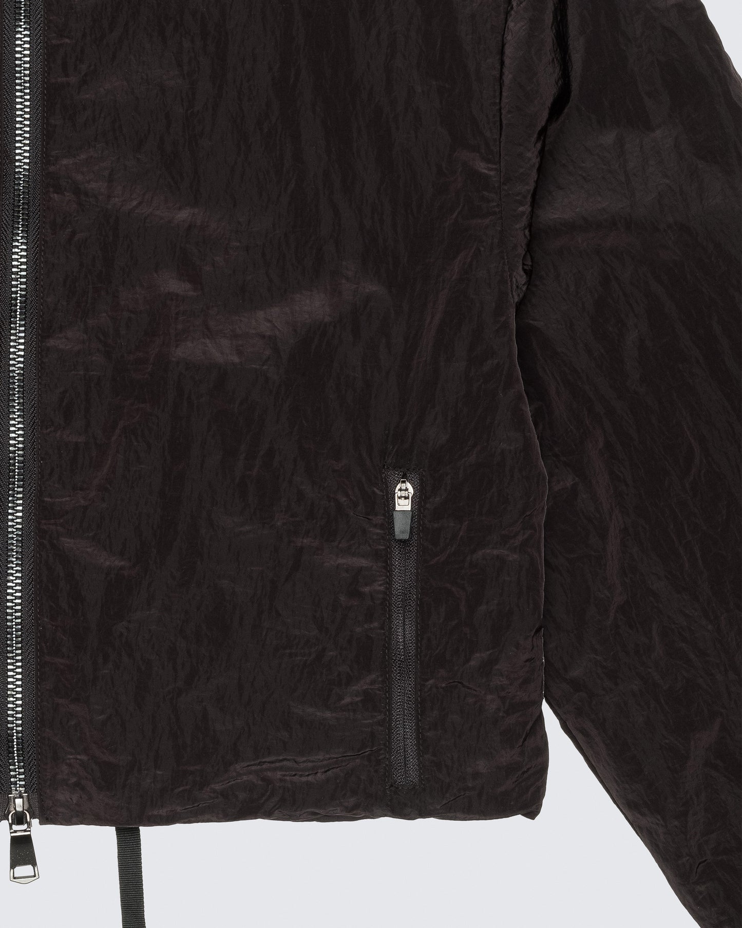 Close-up of 12Twelve crop jacket zipper and pocket seam on textured black fabric
