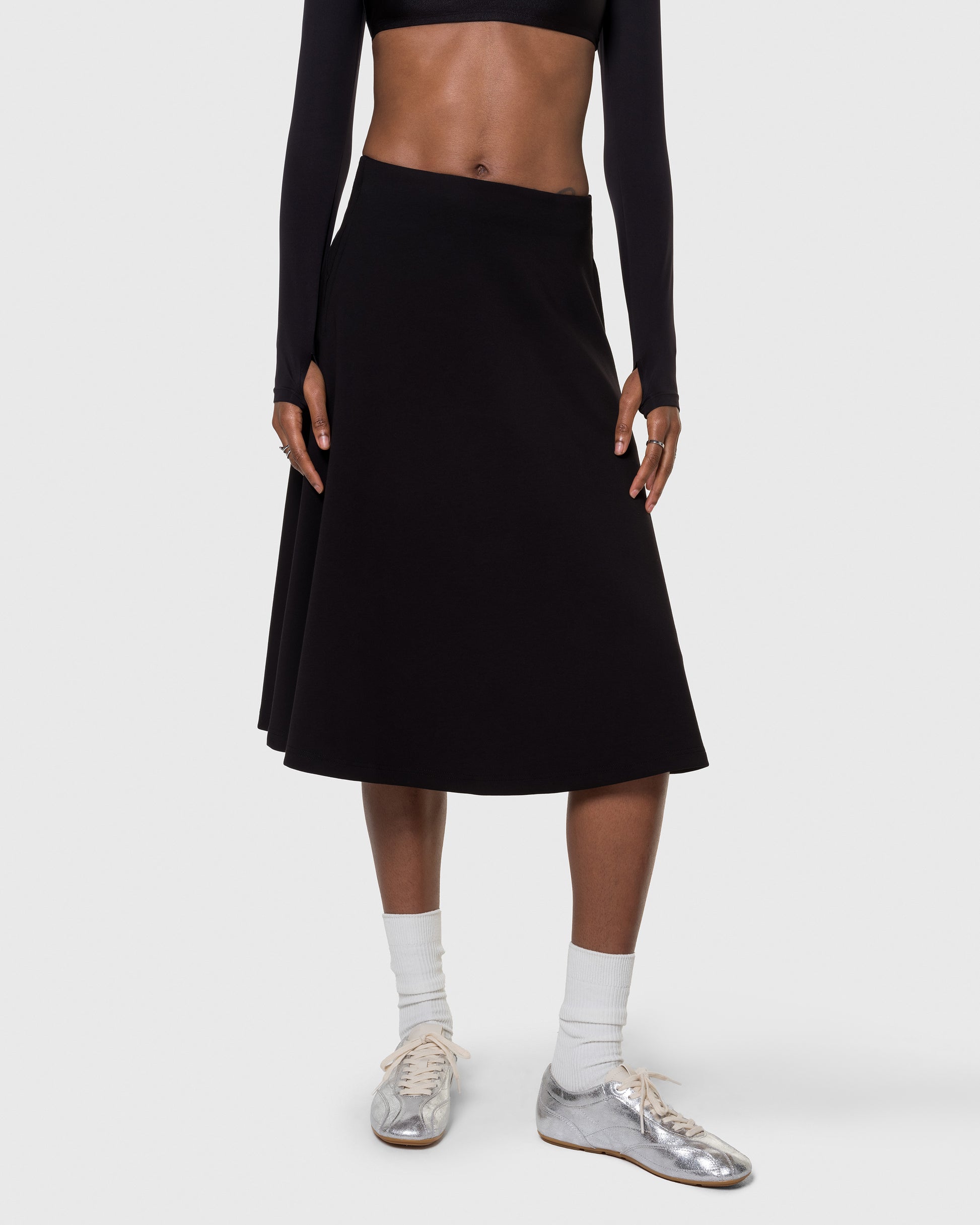 Black Heavenly Skirt styled with crop top, showing mid rise waist and swing shape