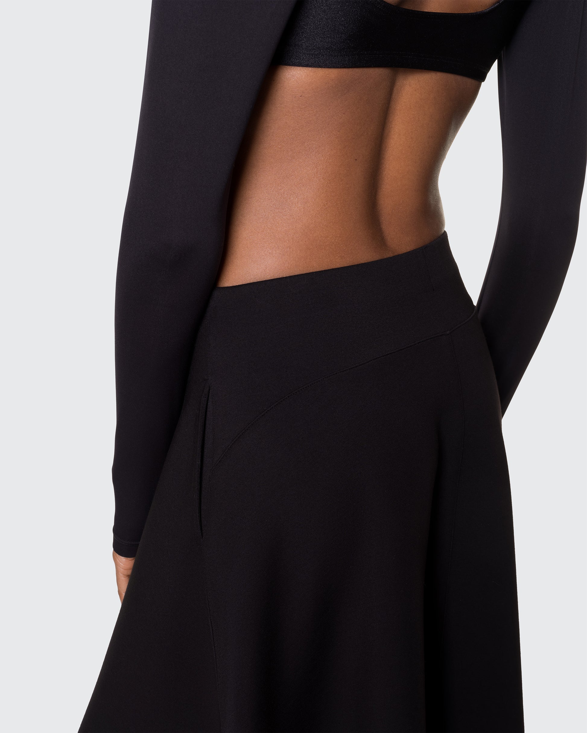 Side rear view of black Heavenly Skirt showcasing smooth seam and drape