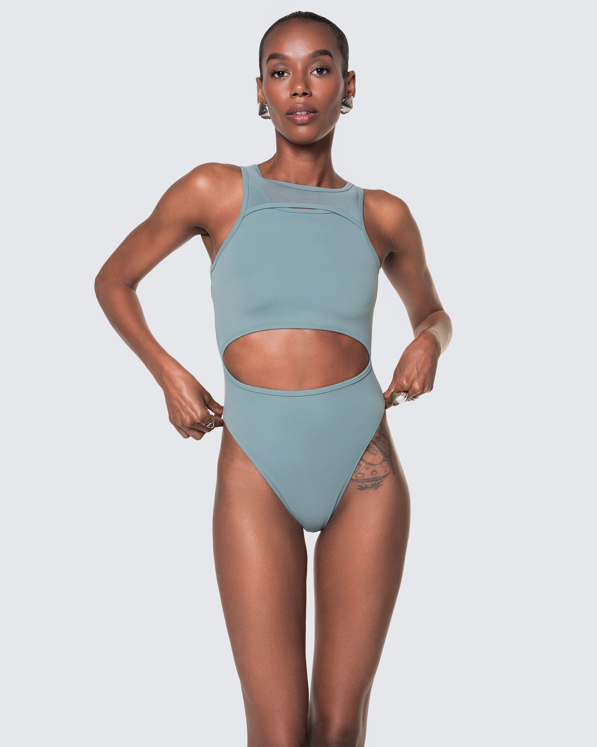 Model wearing 12Twelve tide blue bodysuit with scoop neckline and waist cut-out