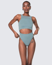 Model wearing 12Twelve tide blue bodysuit with scoop neckline and waist cut-out