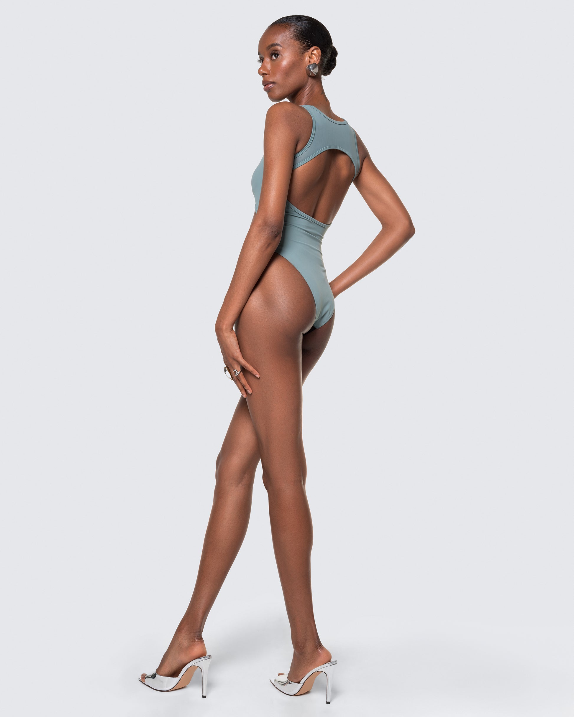 Side view of 12Twelve tide blue bodysuit featuring high-leg silhouette and stretch fit