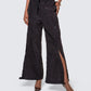Cropped view of 12Twelve black track pants featuring adjustable slit and lightweight textured fabric