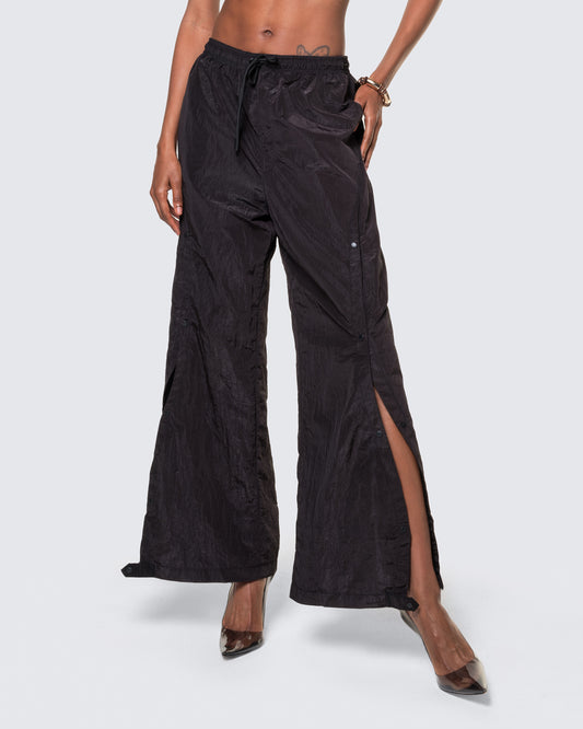 Cropped view of 12Twelve black track pants featuring adjustable slit and lightweight textured fabric
