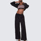 Model wearing 12Twelve black track pants with front view showcasing wide leg and drawstring waist