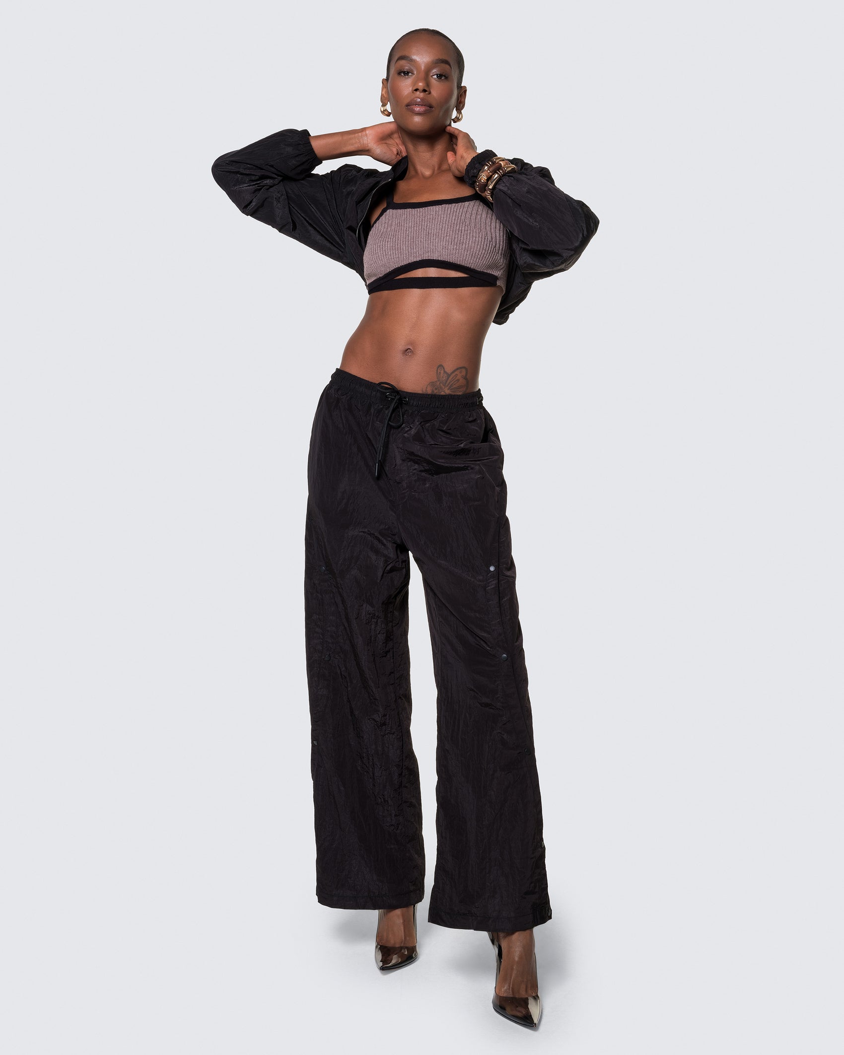 Model wearing 12Twelve black track pants with front view showcasing wide leg and drawstring waist