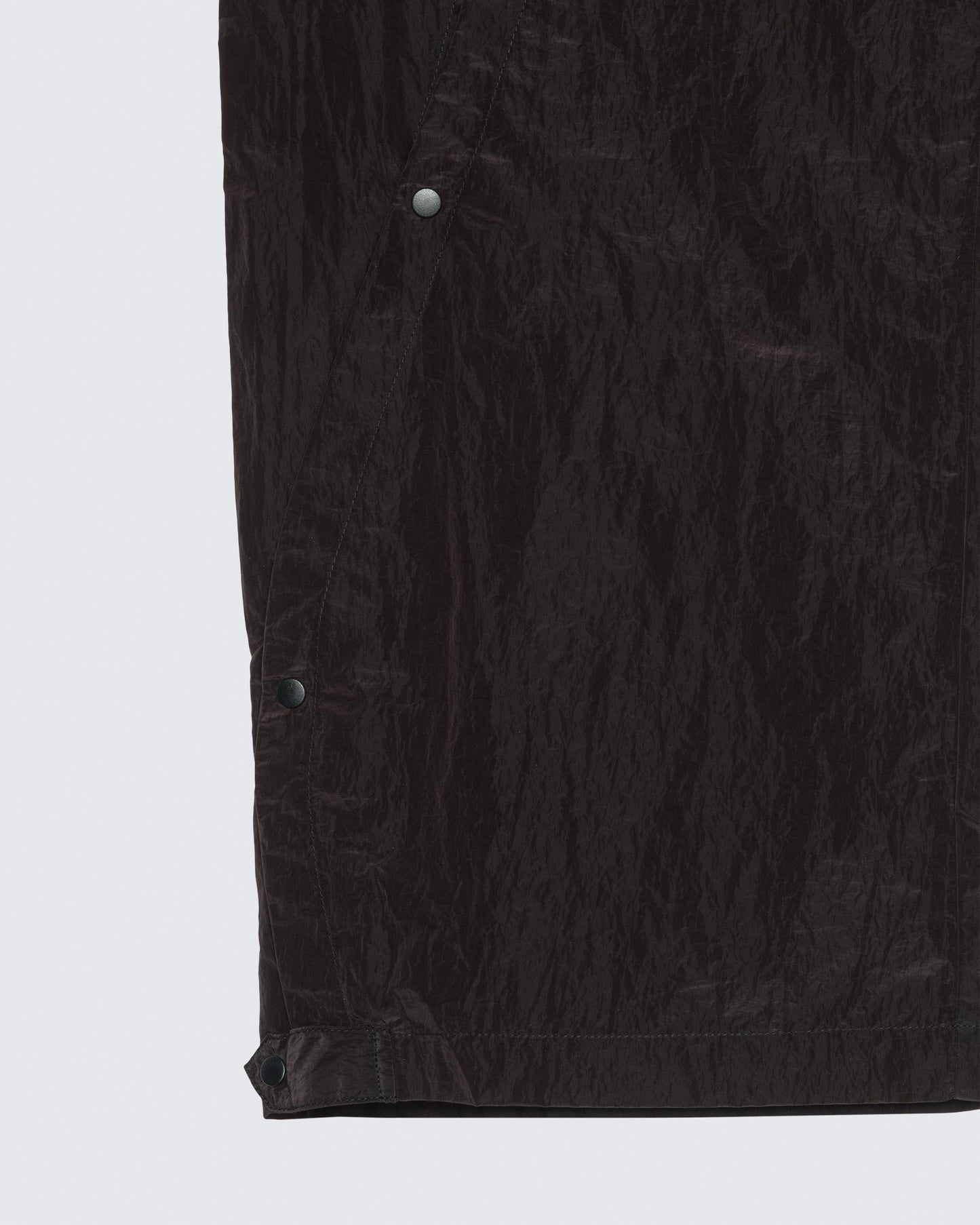 Close-up detail of 12Twelve track pants hem showing fabric texture and snap button hardware