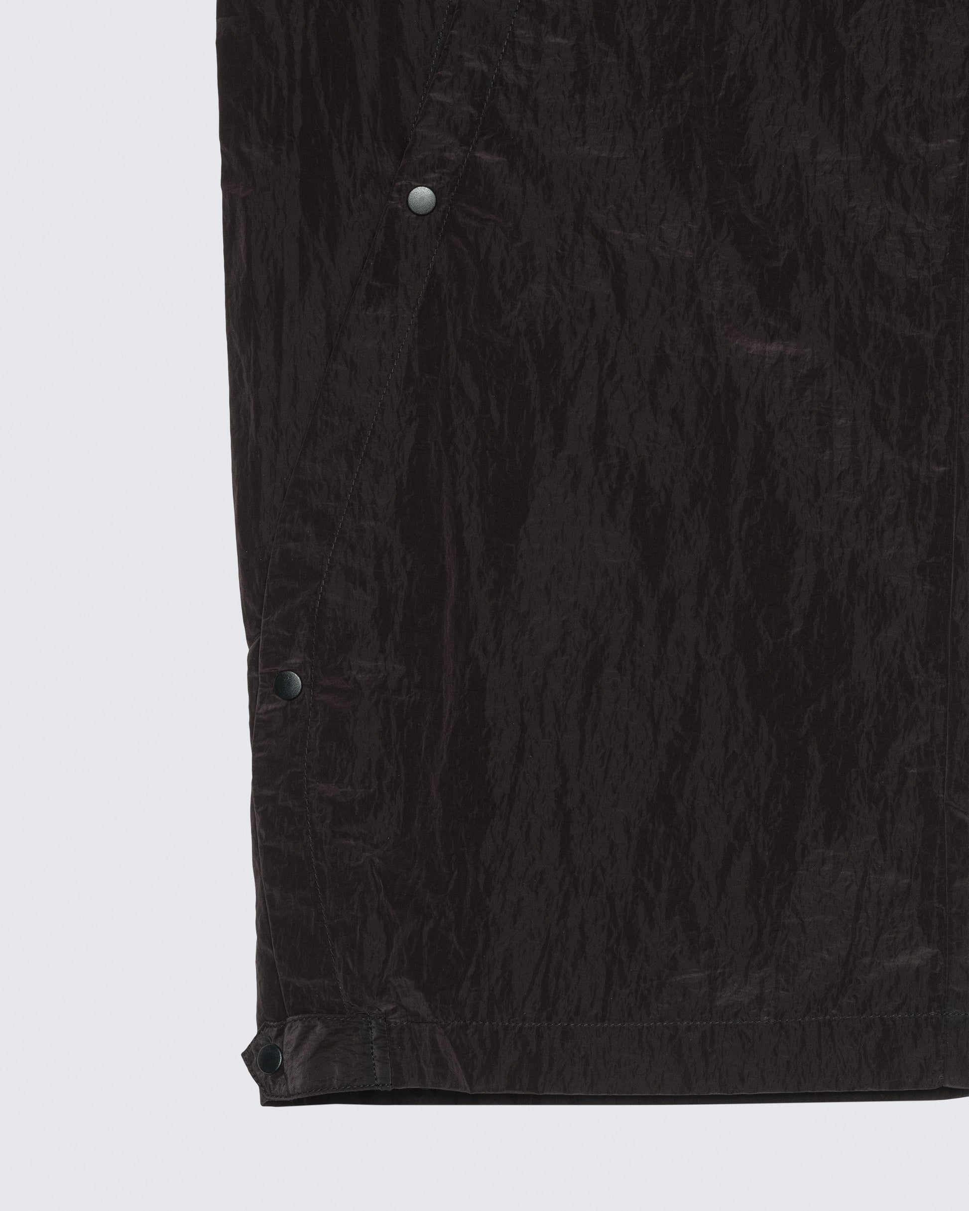 Close-up detail of 12Twelve track pants hem showing fabric texture and snap button hardware