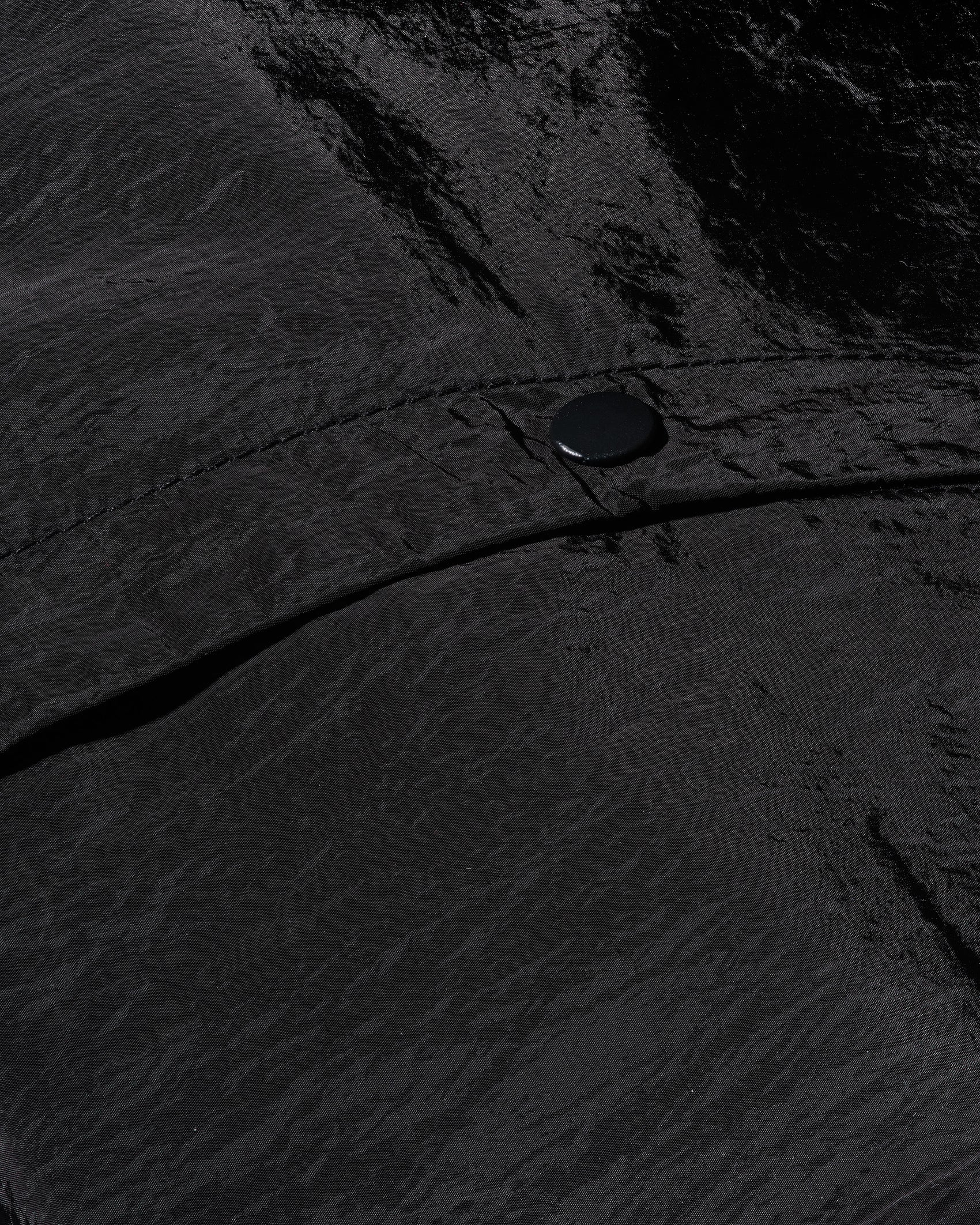 The 12twelve track pant nylon fabric in a close up shot showing the crinkle texture and subtle shine.