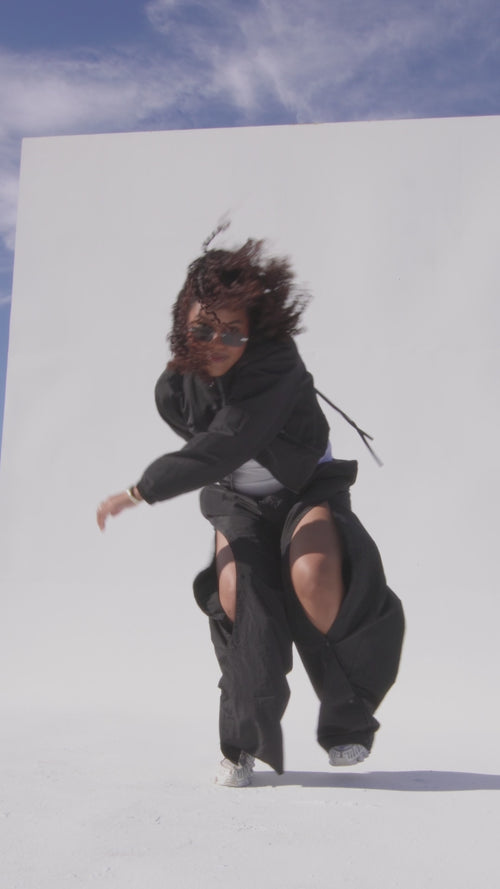Video of a dancer in the 12Twelve Off-Duty Set featuring black Track Pants and Crop Jacket, styled for movement and ease in a modern city backdrop