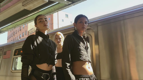 Video of models in the 12Twelve Off-Duty Set featuring black Track Pants and Crop Jacket, styled for movement and ease in a modern city backdrop